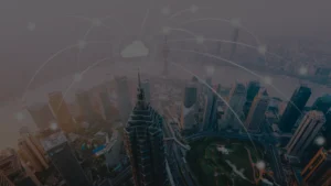 Imagem vista de cima e lateral de uma cidade com grandes pédios, áreas verdes e sistemas tecnológicos, representando as cidades inteligentes.